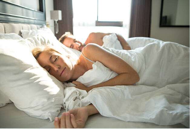 Casal dormindo tranquilamente em cama confortável