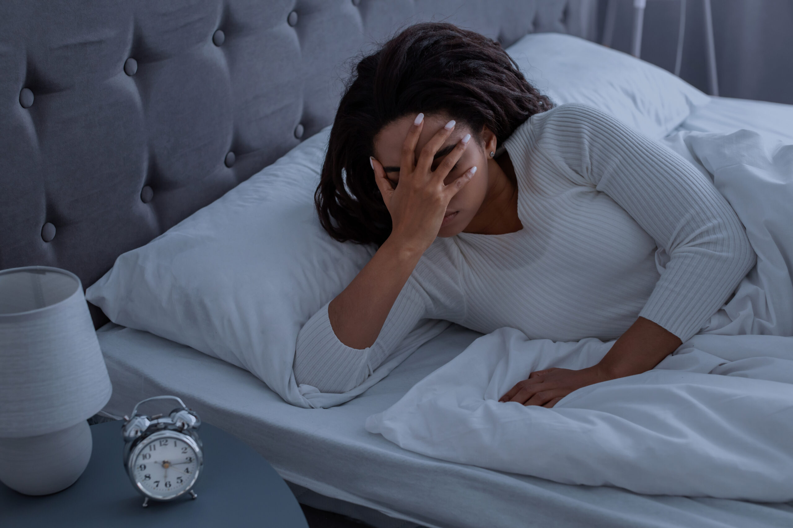Black woman suffering from insomnia covering face Mulher com insonia a noite