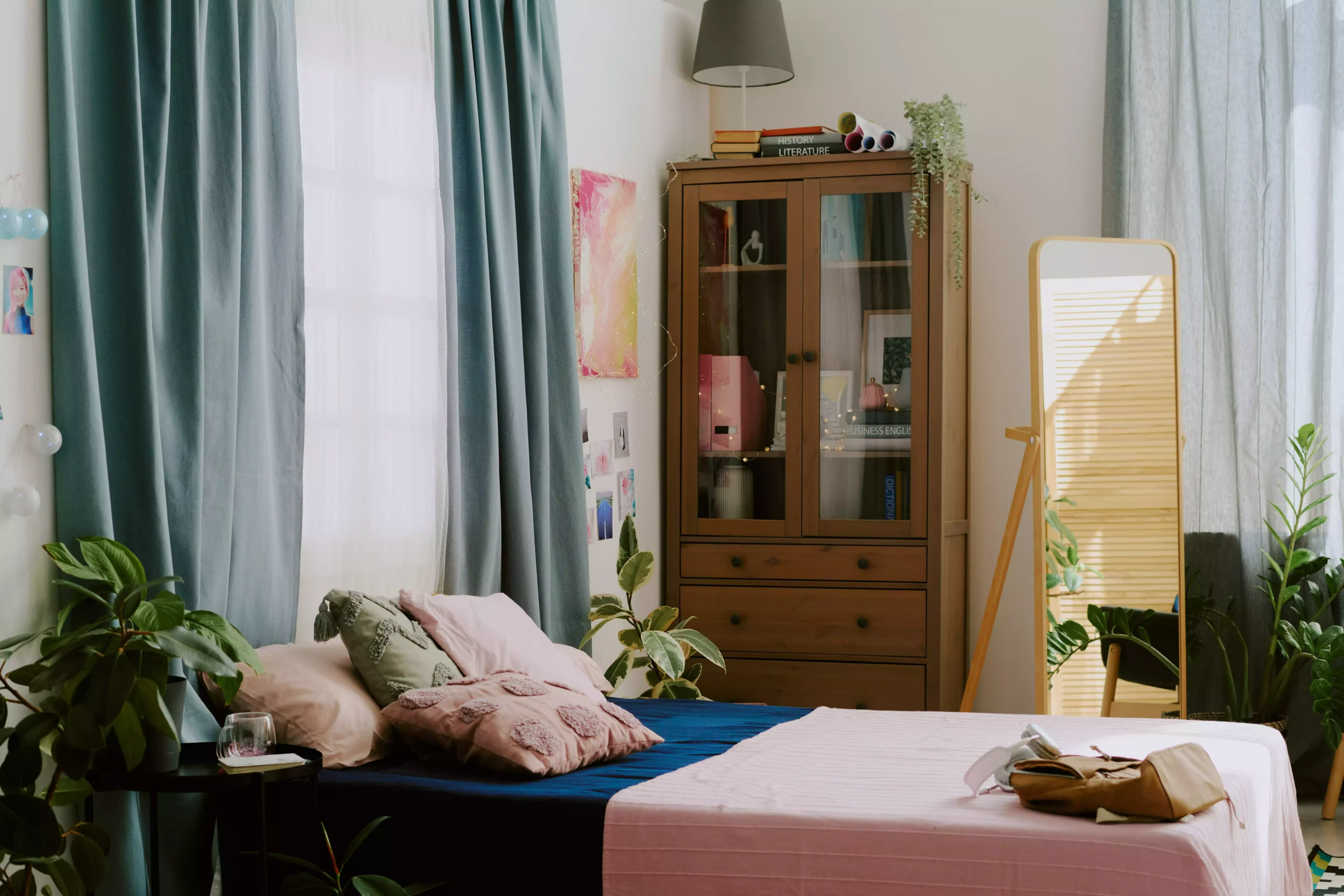 cozysunlitbedroomwithhouseplantsandbookshelf20250211125728utc Cama organizada ao lado de um armário