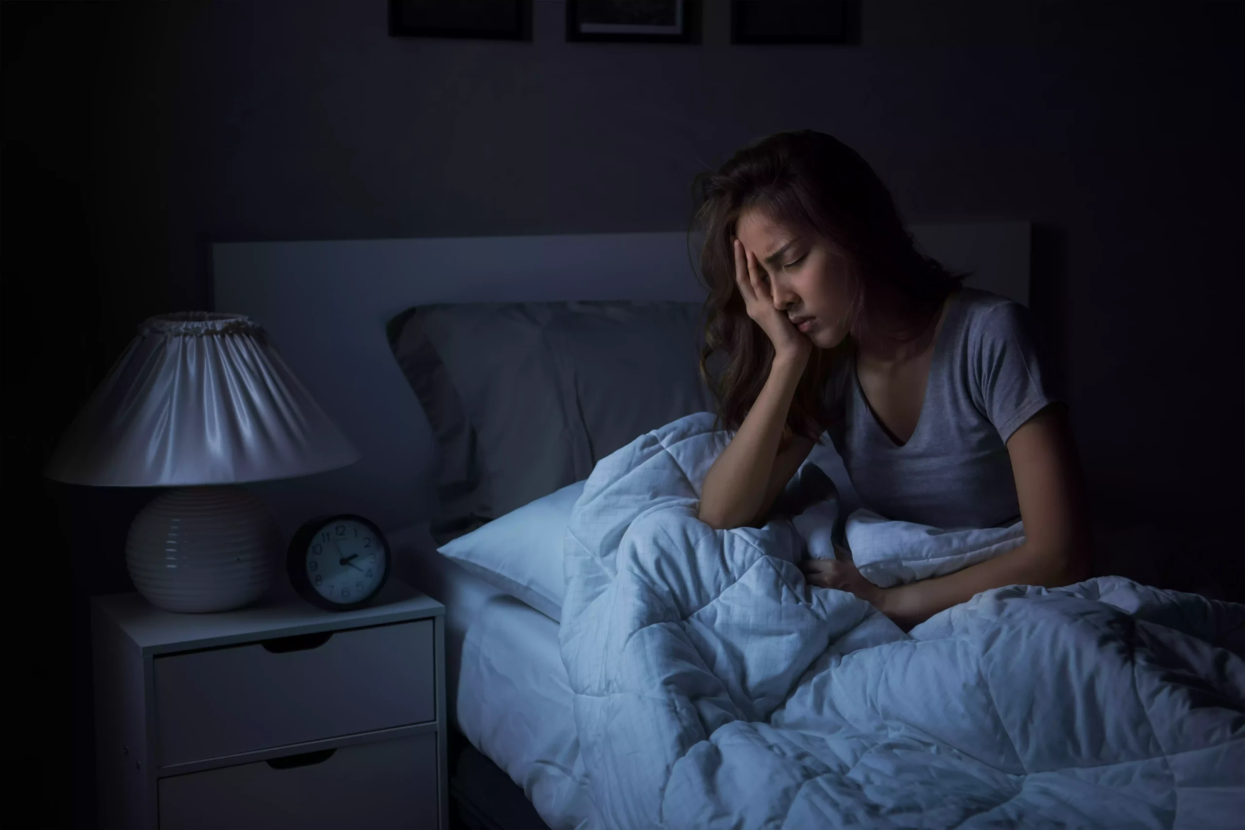 womaninsomnia20250108074218utc Mulher sentada na cama a noite sem conseguir dormir