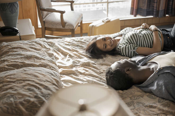 Casal deitado na cama olhando um para o outro