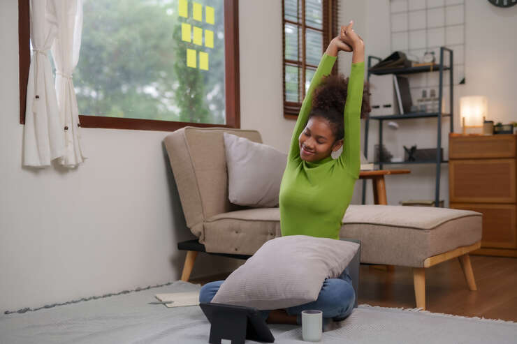 Mulher sentada no chão se alongando
