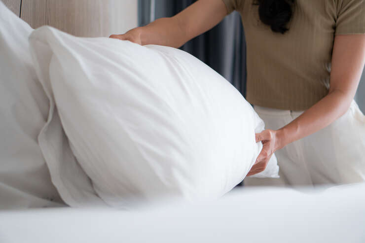 Mulher afofando o travesseiro