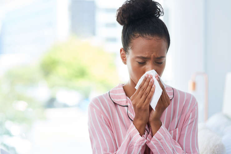 Mulher assoando o nariz