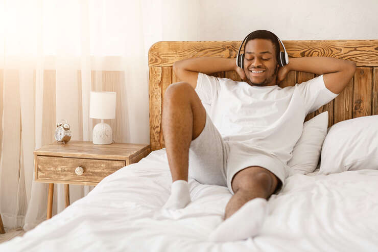 Homem deitado sorrindo com fone de ouvido