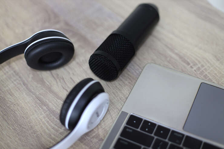 Fone de ouvido ao lado de um notebook em cima da mesa