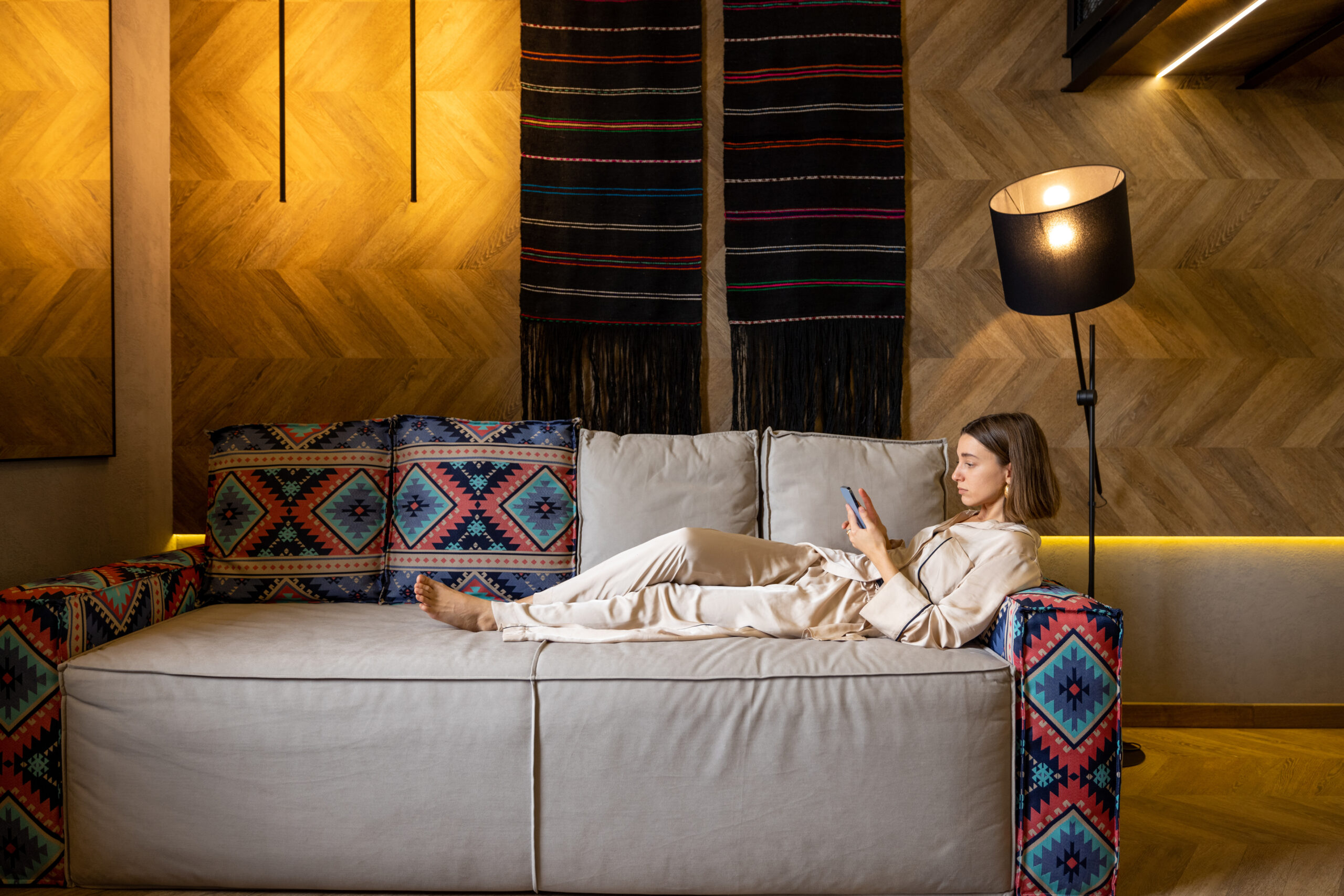 Mulher deitada no sofa mexendo no celular