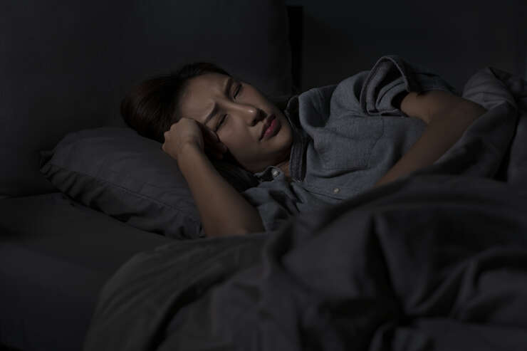 Mulher deitada sem conseguir dormir