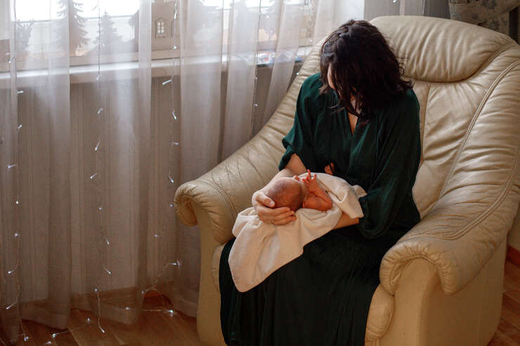 Mulher segurando um bebê em um sofá