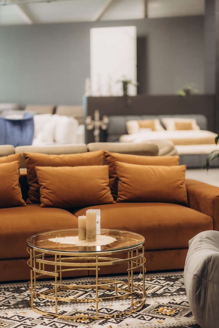 Sofá laranja com mesa de centro elegante em ambiente aconchegante