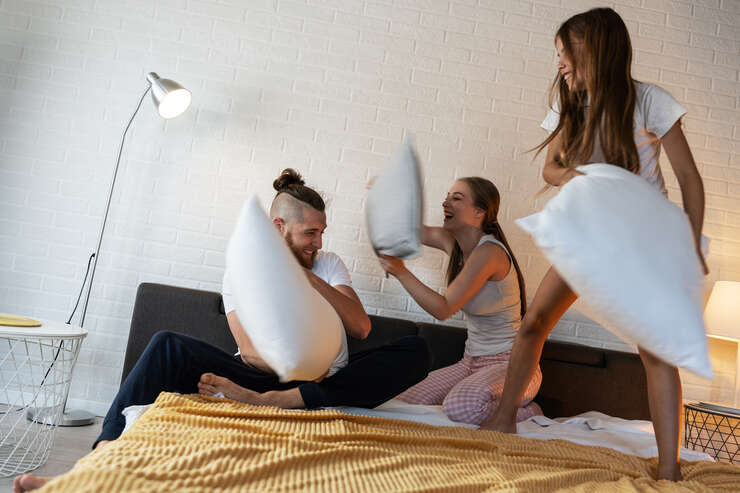 Diversão com travesseiros em quarto aconchegante