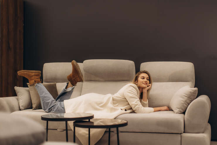 Mulher relaxando em sofá moderno e confortável.
