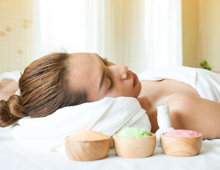Mulher relaxando em spa com cremes de beleza