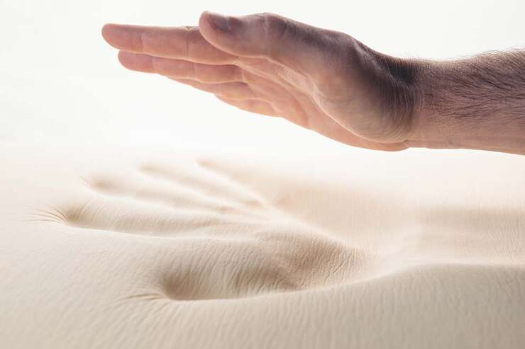 Mão criando impressão em superfície macia