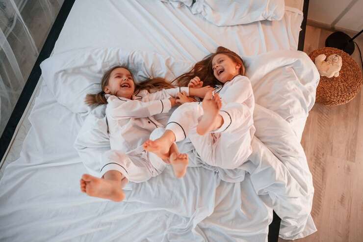 Meninas brincando na cama feliz